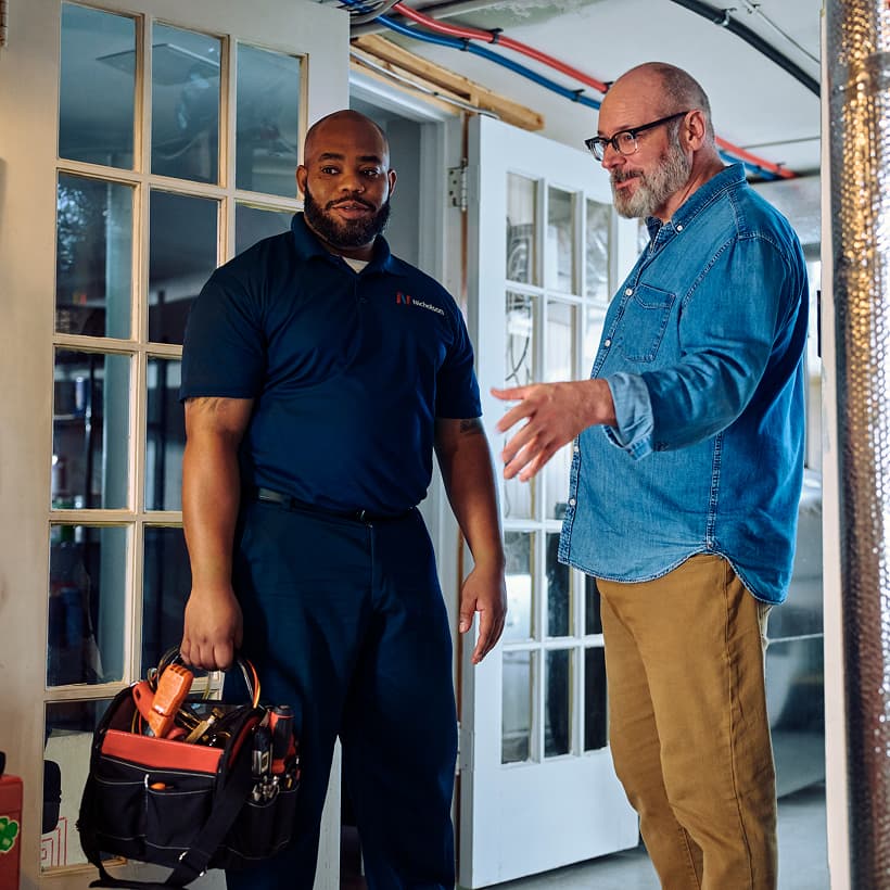 A Nicholson technician discusses the repair and installation services with a homeowner.