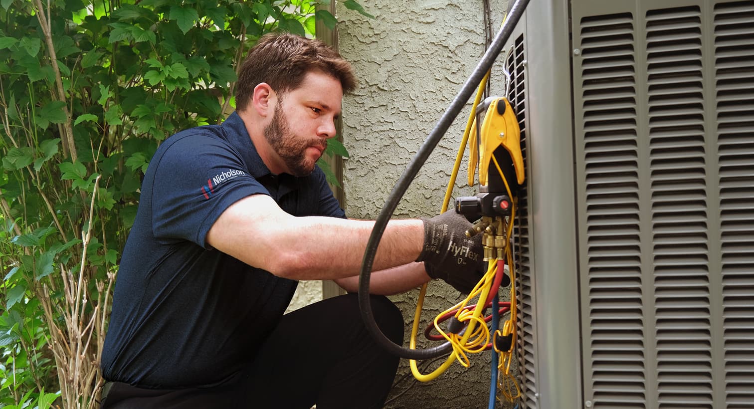 A professional Nicholson HVAC technician inspecting an outdoor central air conditioning unit to provide residential AC repair and diagnostic services.