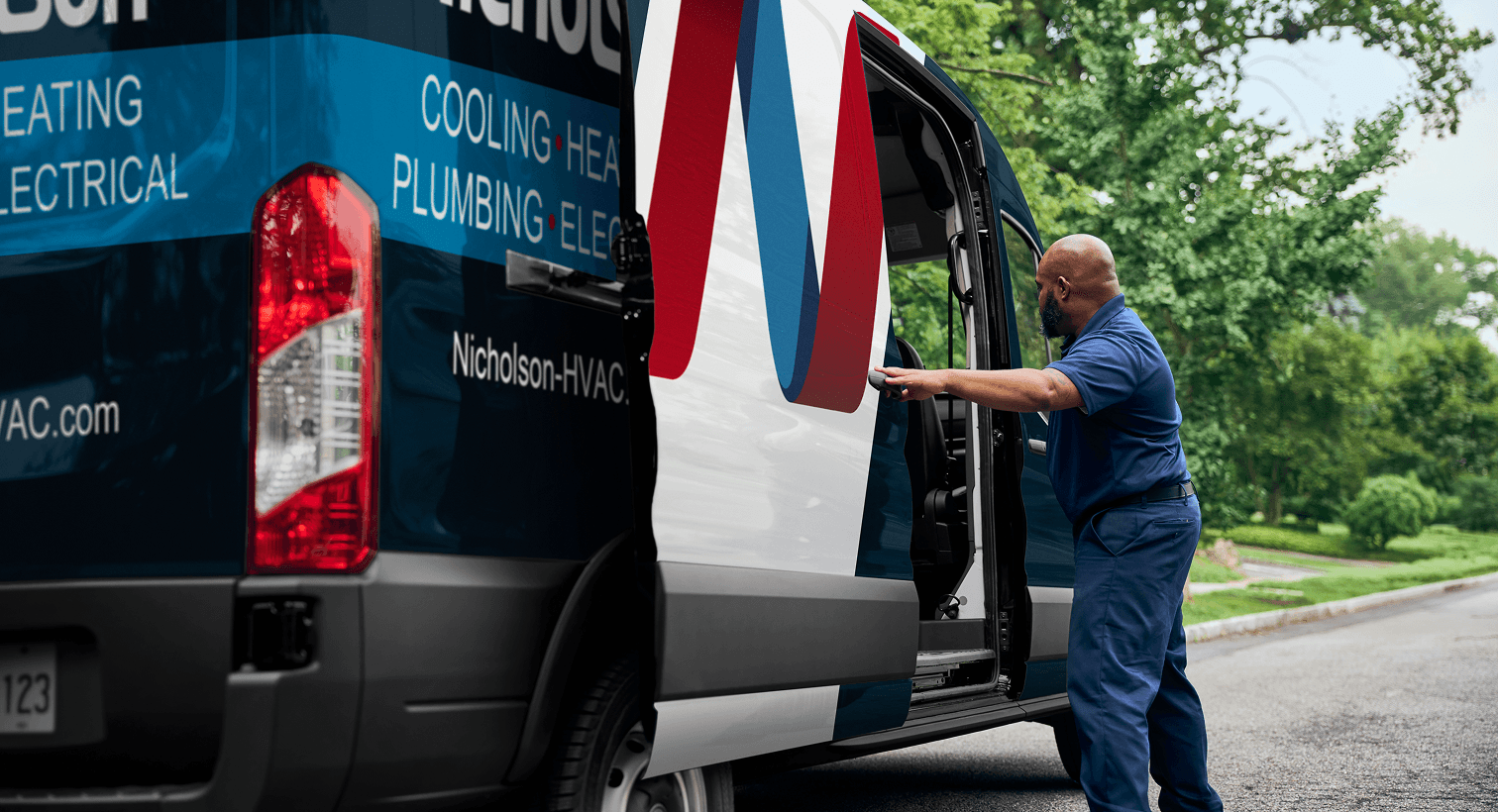 A professional Nicholson technician opening a service van on a residential street, ready to provide home HVAC, plumbing, and electrical services.